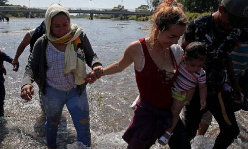 Caravan Migrants Cross Mexico River, Throw  Rocks at Country’s National Guard in  Response to Tear Gas